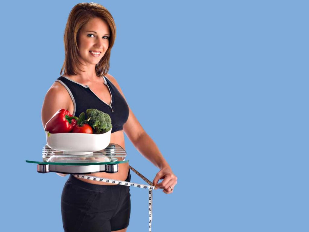 lady holding weighing scale vegetables and inch tape