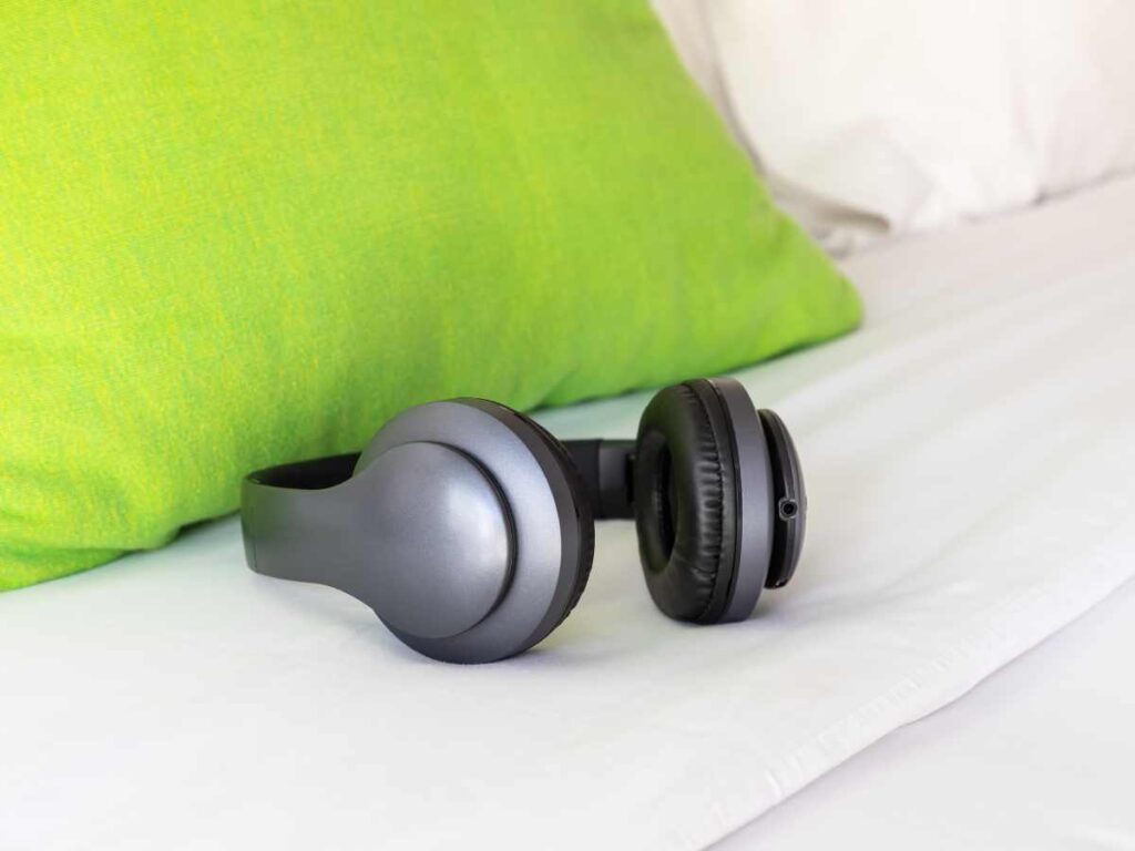 headphones and pillow lying on bed