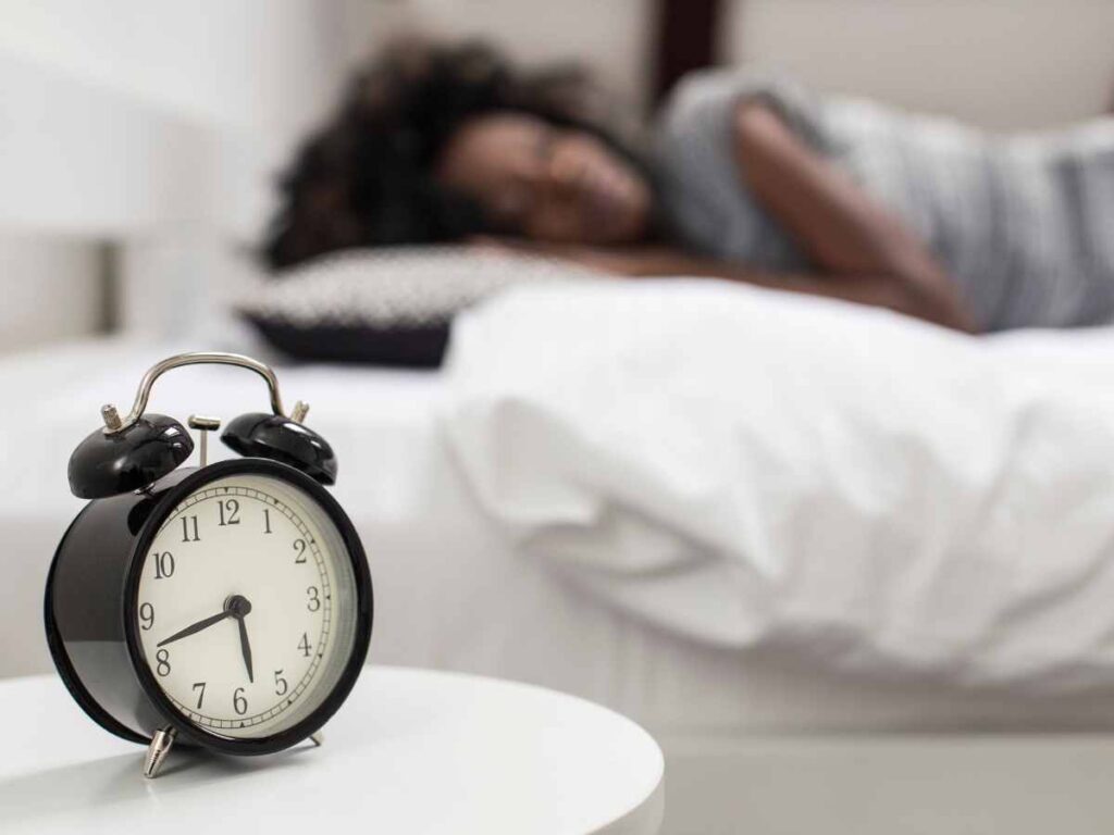 lady sleeping with an alarm clock