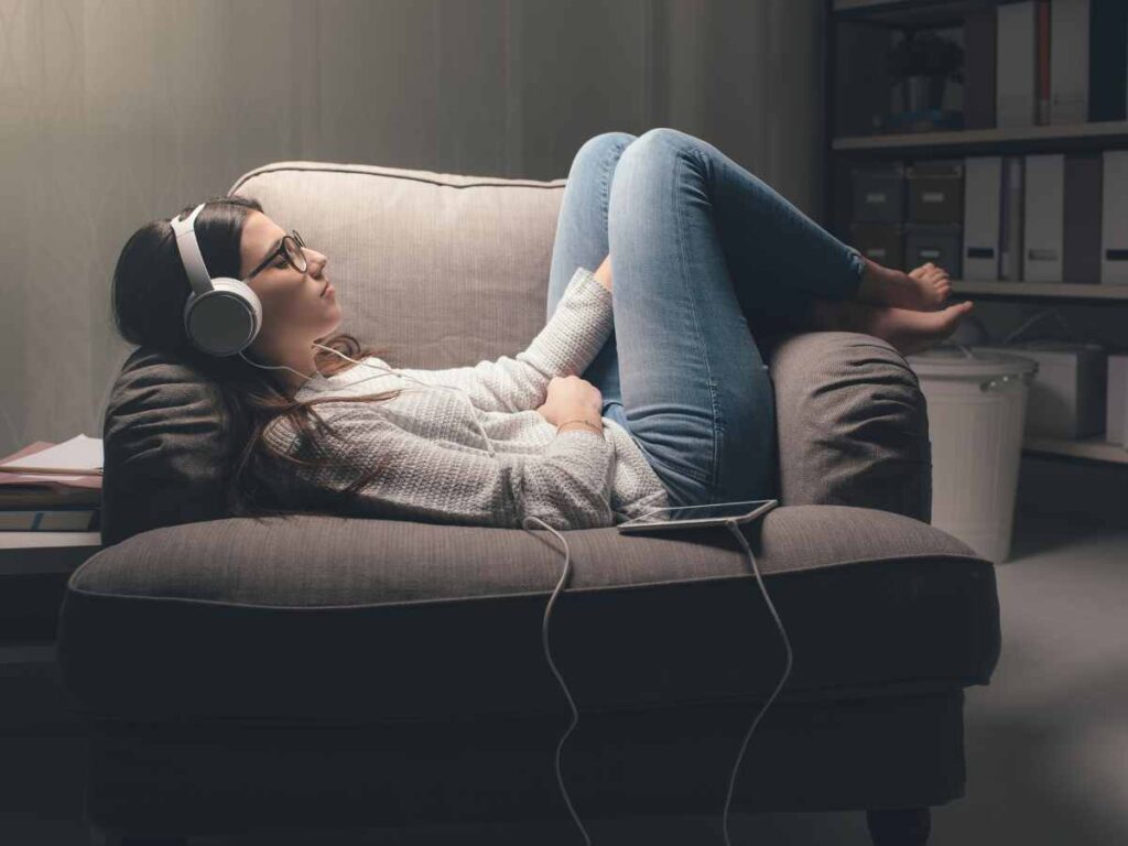 lady sleeping on sofa with headphones on