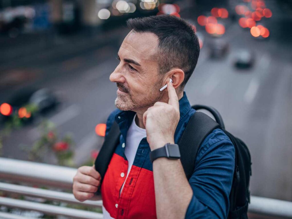 a man in traffic wearing noice cancellation earbuds