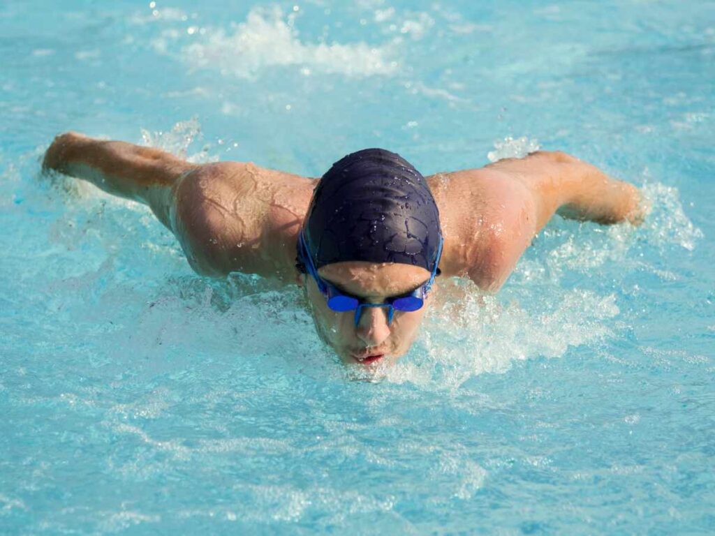 man completing laps in swimming in the pool