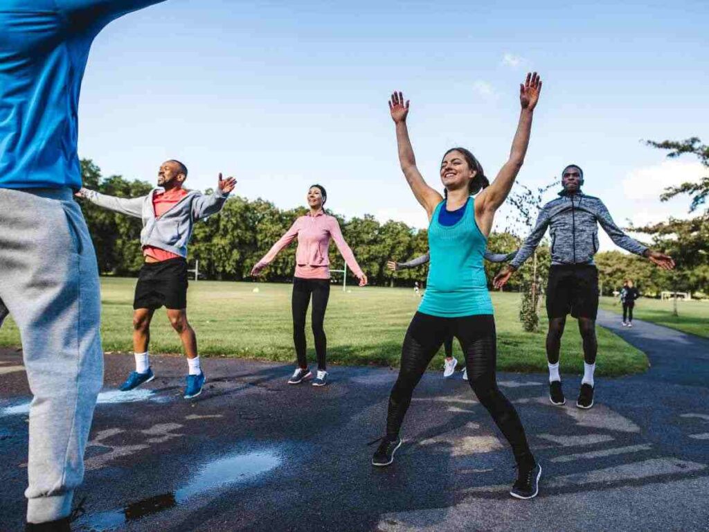 group of people doing jumping jacks in the park