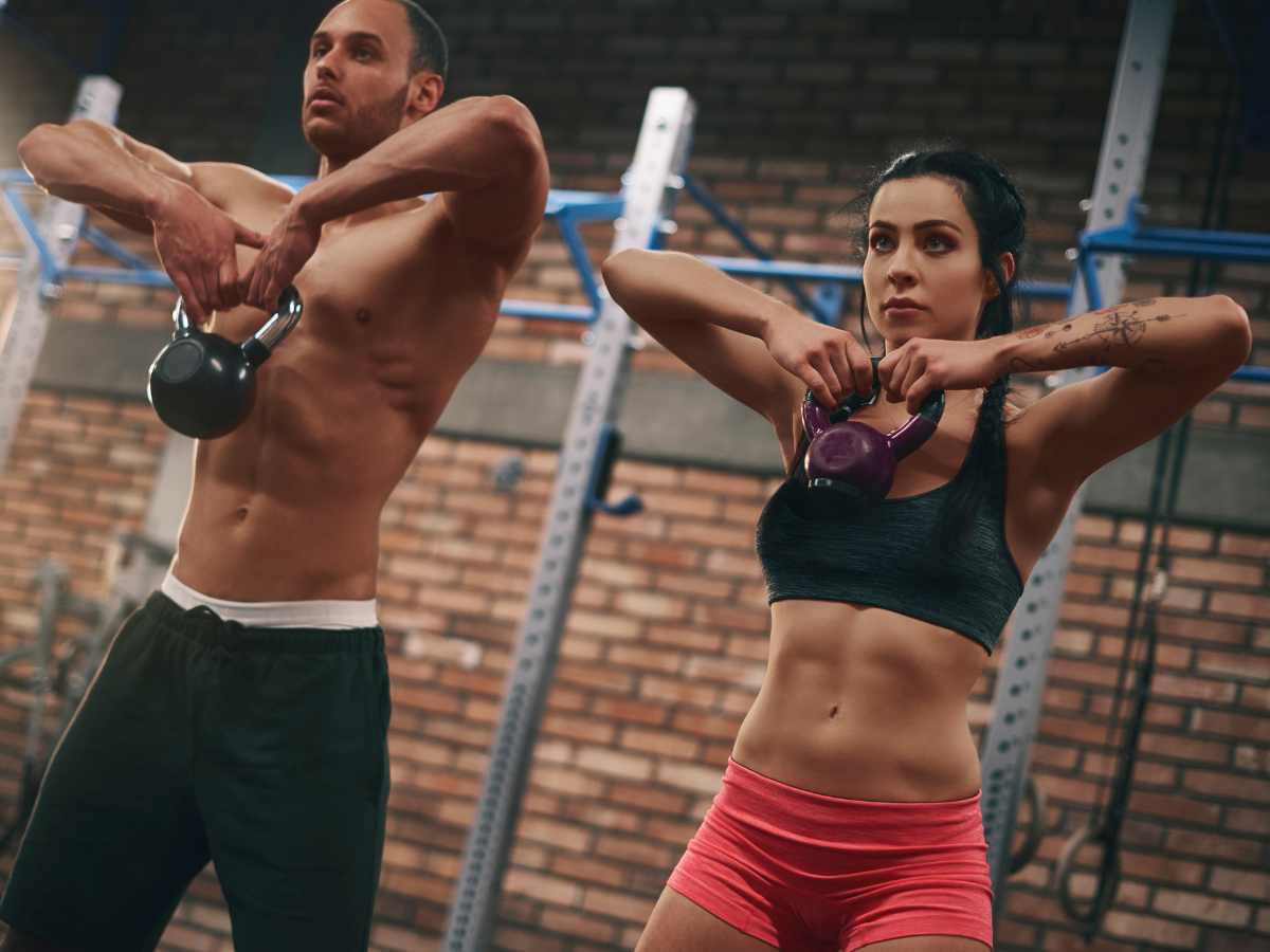 couple doing kettlebell workout at the gym