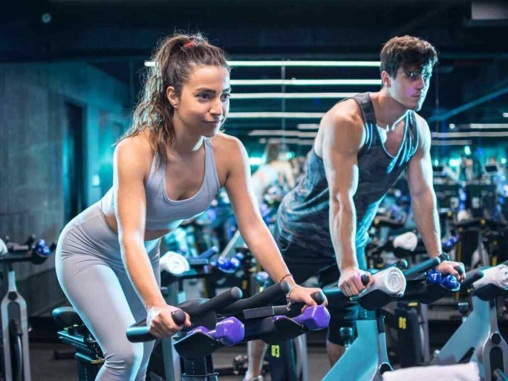 couple doing stationary cycling at the gym