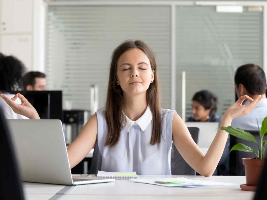 lady managing stress in her office by meditating