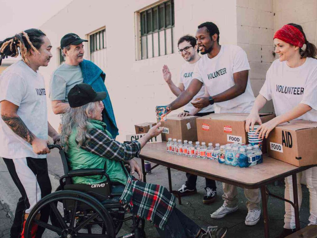 group of people working a volunteer to help others